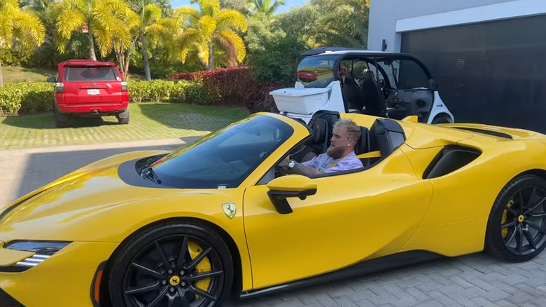 Jake Paul driving a yellow Ferrari S90 Spider.