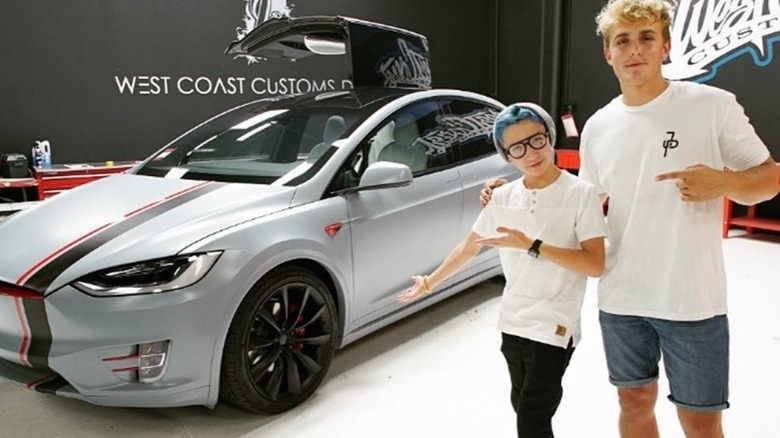 Jake Paul posing with his customized silver Tesla.