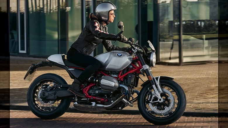 A BMW R 12 nineT riding past a glass store front.