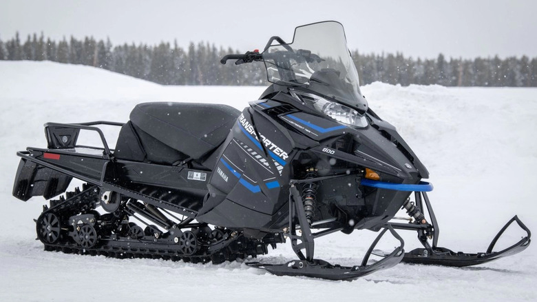 Rider in black gear on Yamaha's black and blue Transporter 800 snowmobile