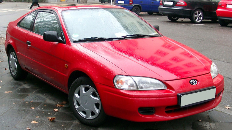 Red Toyota Paseo parked on city street