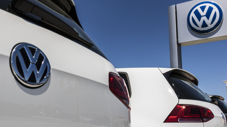 White Volkswagen cars under a Volkswagen banner