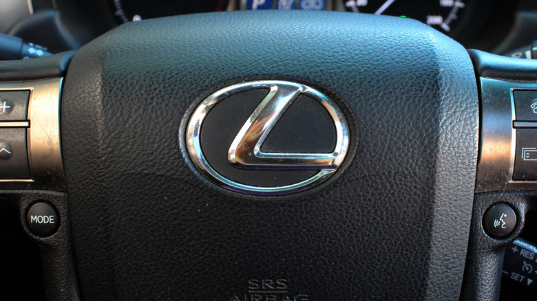 The Lexus logo is shown on a steering wheel.