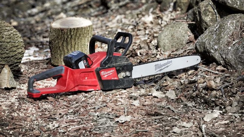 Milwaukee chainsaw on ground in forest