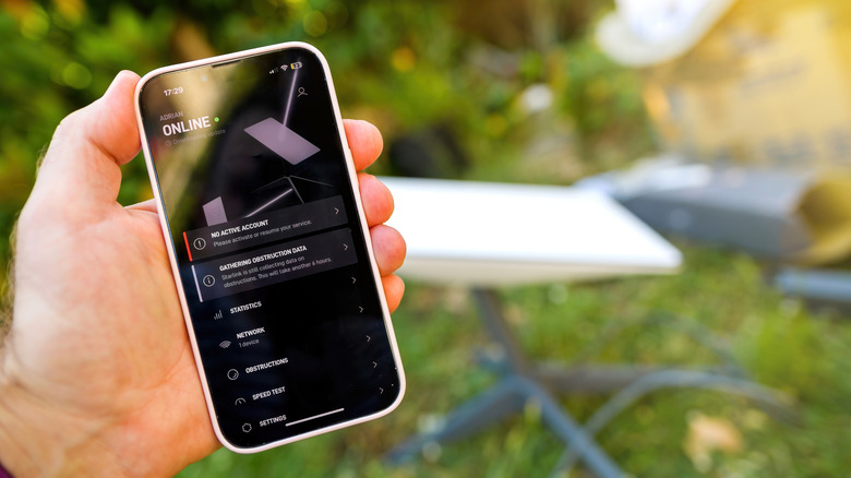 Person holding phone with Starlink app open displaying network information