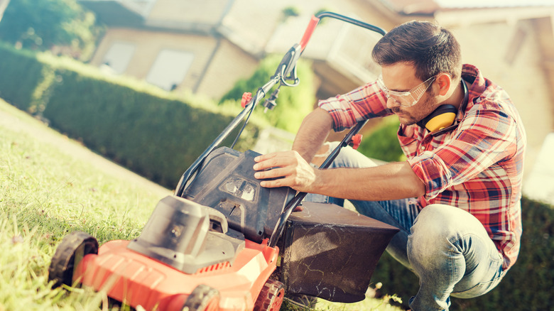 Man checking lawn mower