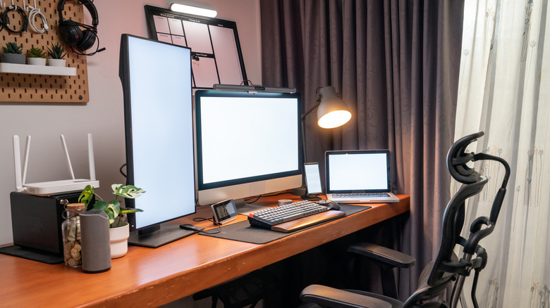 A home office with multiple devices on a table.