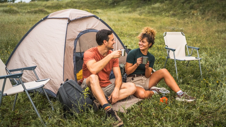 Couple having coffee at campsite