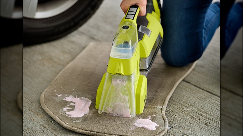 person using ryobi spot cleaner