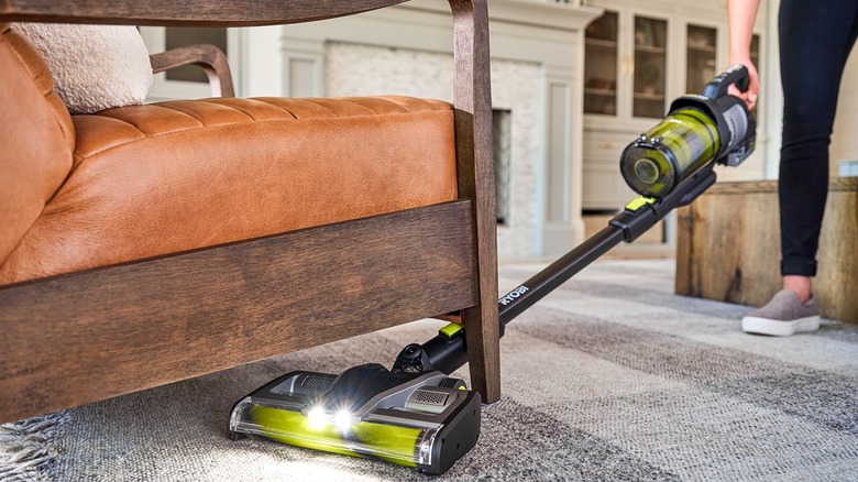 person using ryobi stick vacuum