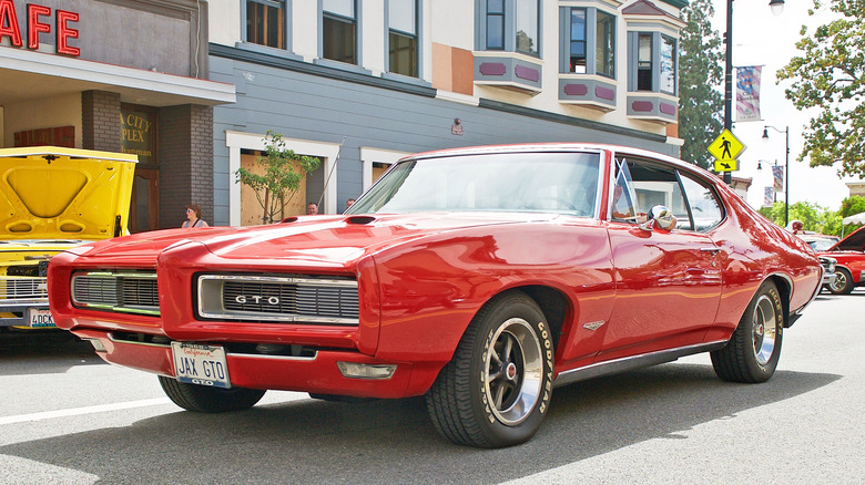 Red 1968 Pontiac GTO parked on town's main street