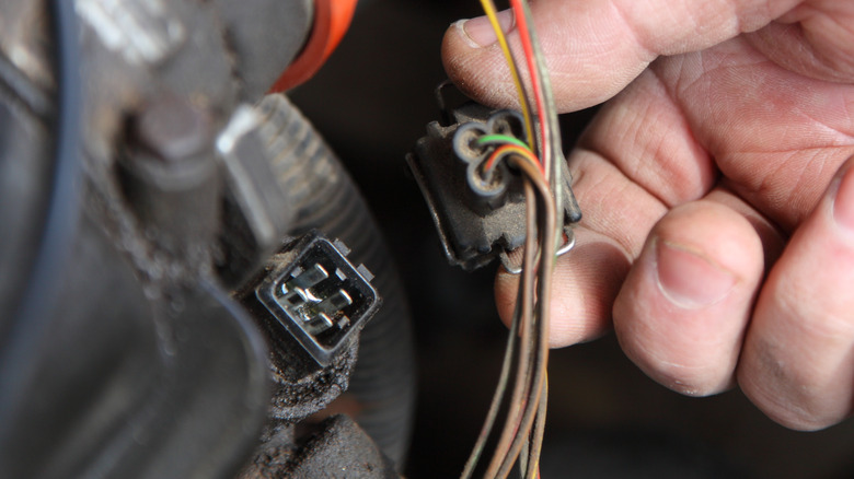 Mechanic checking coolant temperature sensor