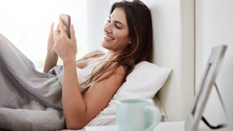 Woman using her phone in bed