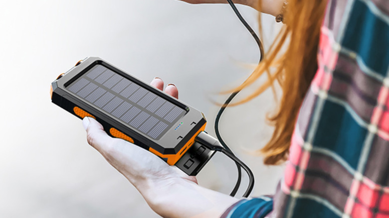 person holding a solar phone charger