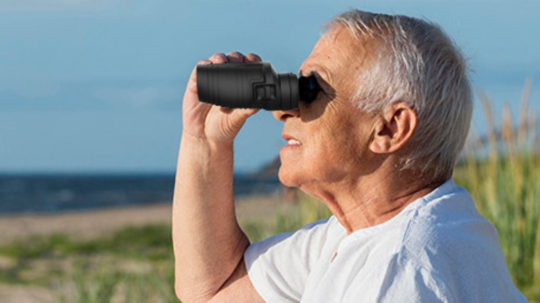 man holding binoculars up to his eyes