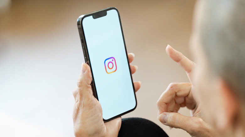 Woman hand holding iphone with logo of instagram