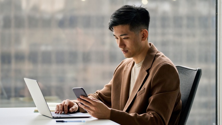 Man using laptop and smartphone 