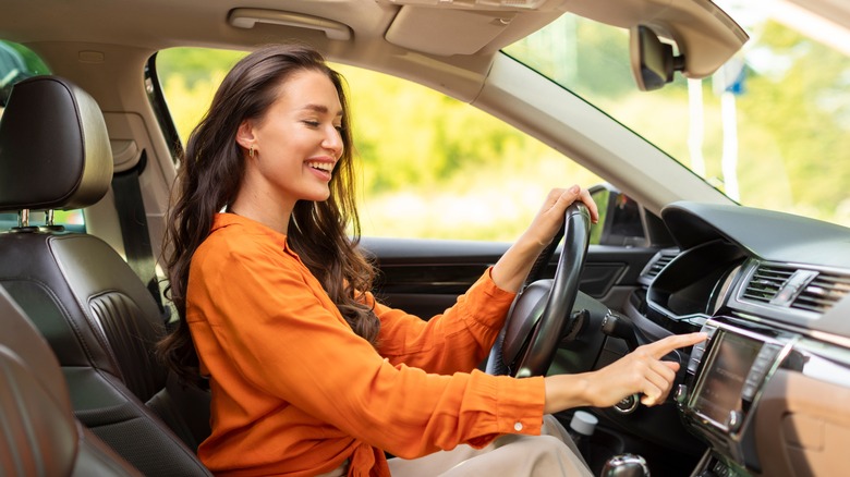 person turning on car radio