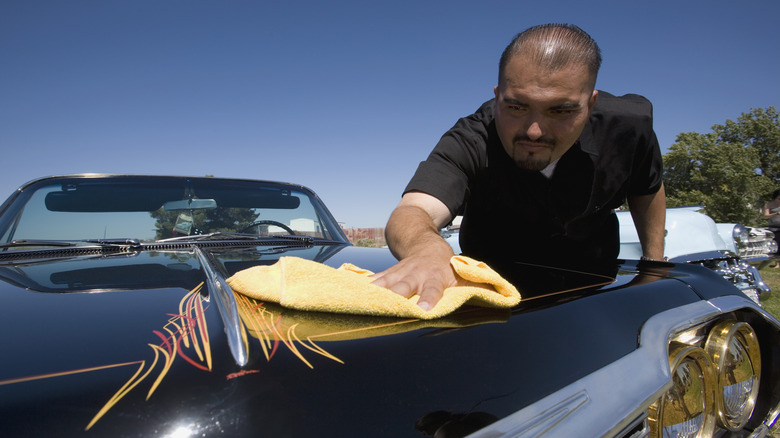 Man hand waxing a custom car