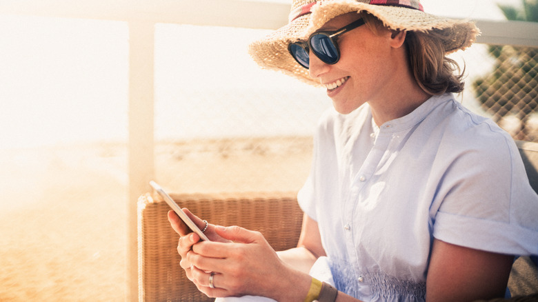 Woman holding phone on sunny day