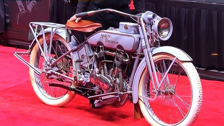 A white 1916 Harley-Davidson J on a red carpet