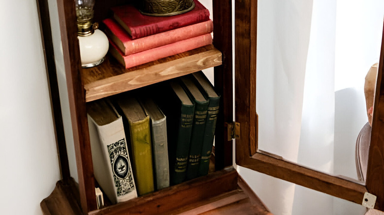 A grandfather clock turned into a bookshelf.