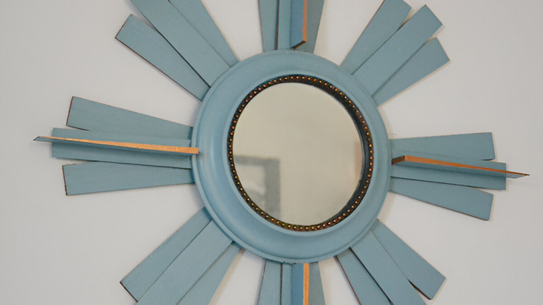 A wall clock transformed into a sunburst mirror.