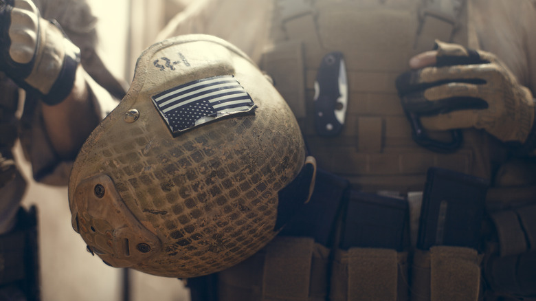 Army helmet being held by a soldier