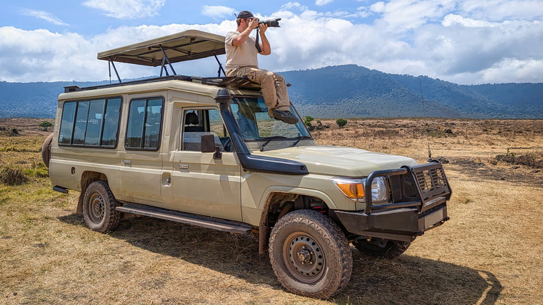 Man taking photo on top of Jeep hard top