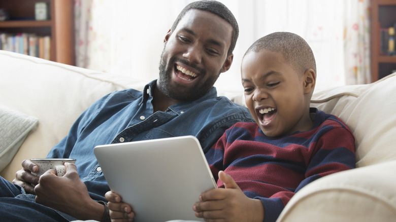 Father and son enjoying videos on a tablet together