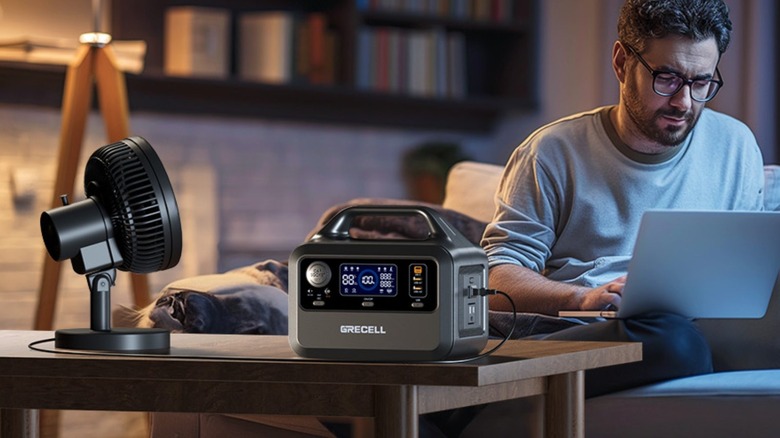 Power station sitting on top of table next to a portable fan