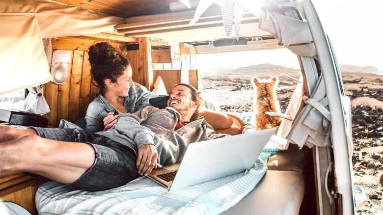 A couple laying in bed in a camper van