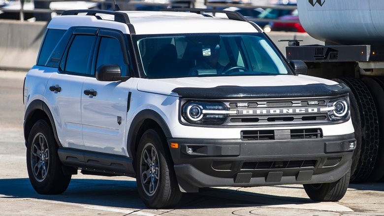 white Ford Bronco Sport parked beside a fuel truck