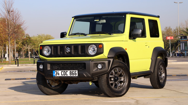 light green Suzuki Jimny in empty parking lot