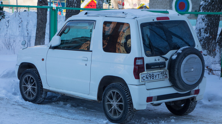 Rear view of a white Mitsubishi Pajero Mini parked in the snow