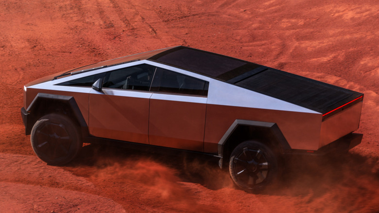 Side view of Tesla Cybertruck sliding on red dirt