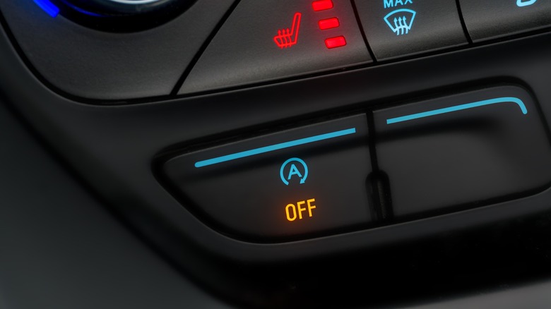 A Close Up Of An Auto Start-Stop Disable Button On Vehicle Dashboard