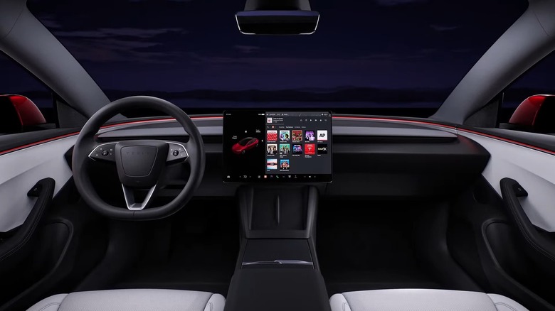 A Tesla Model 3 Interior Shot Of The Dashboard Showing A Massive Media Screen And Only A Few Buttons On The Steering Wheel