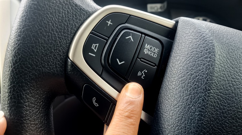 Person Preparing To Press The Voice Command Button On The Steering Wheel