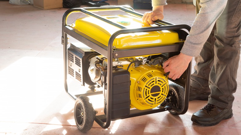 Man starting portable power generator