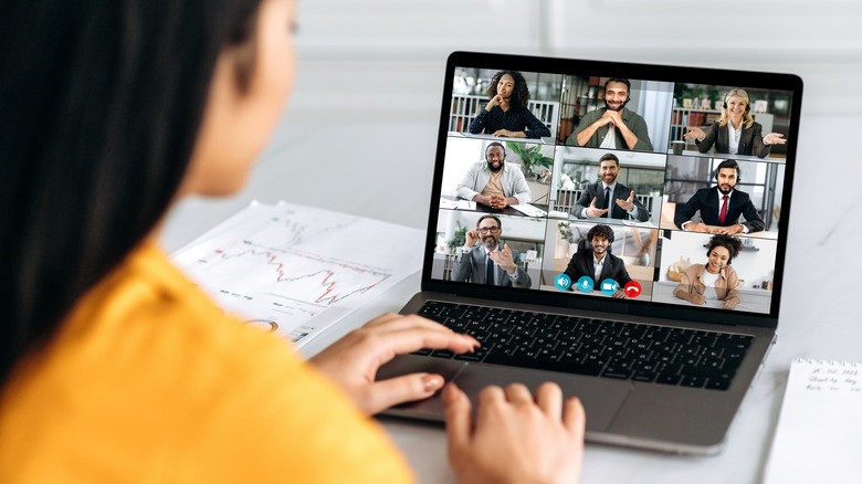 woman with black hair in yellow top having a video call