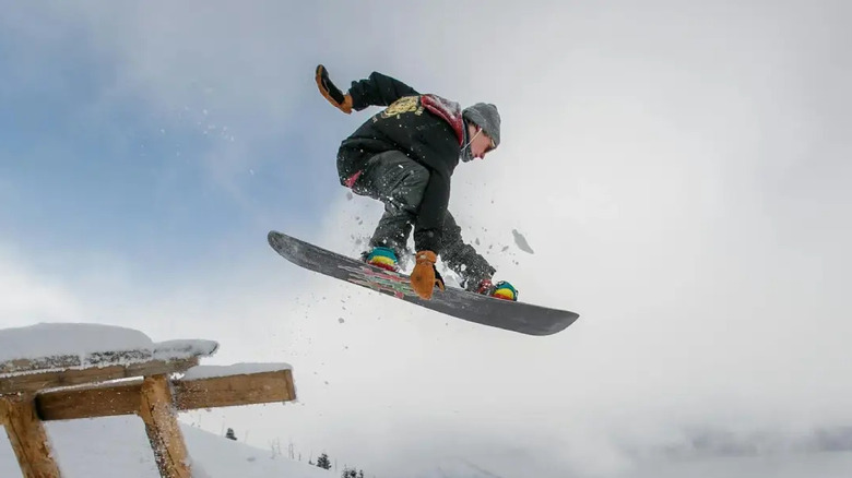 Guy doing jump trick on a snowboard