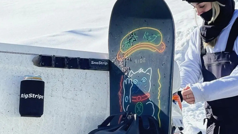 Snowboard hanging on a SnoStrip on the side of a truck