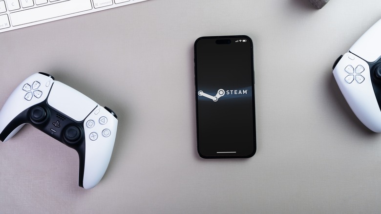 Steam logo on mobile phone beside PS controller