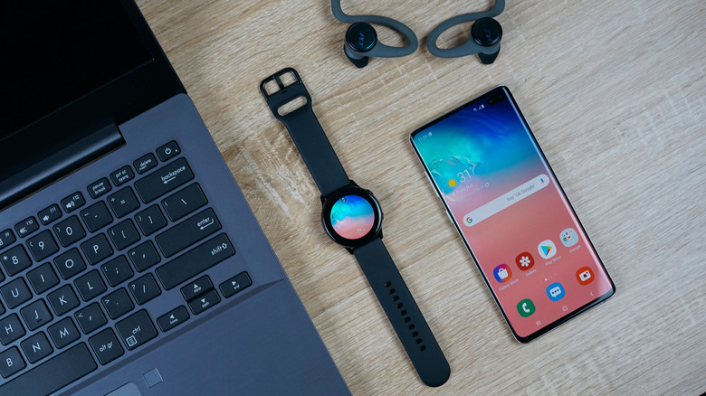 a laptop, smartwatch, and Android phone on a table