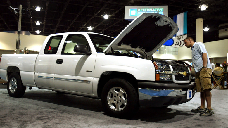 person looking under hood of silverado