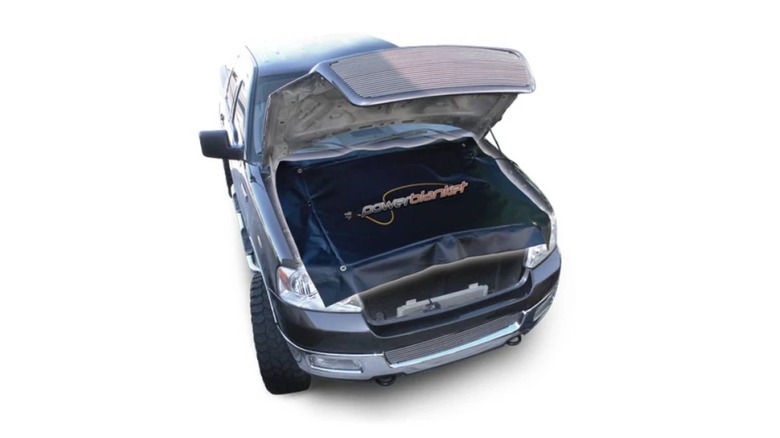 Diesel engine-warming blanket covering truck engine