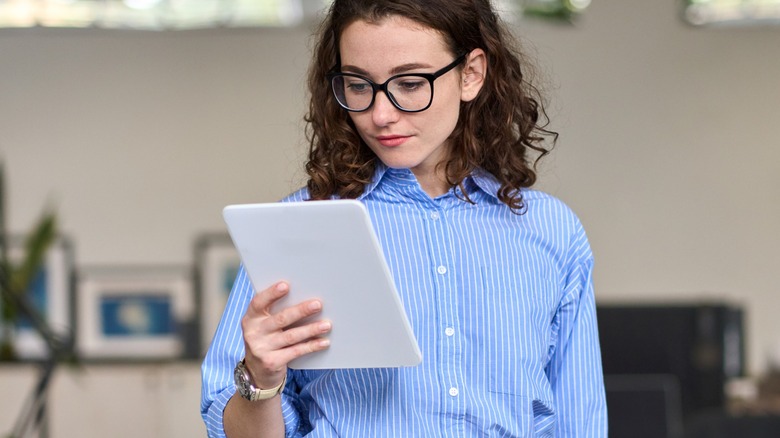 Woman with glasses looking at tablet