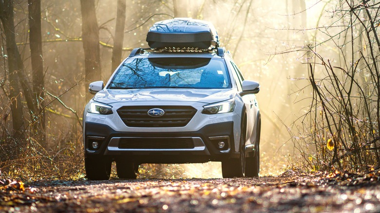 White Subaru Outback in the woods