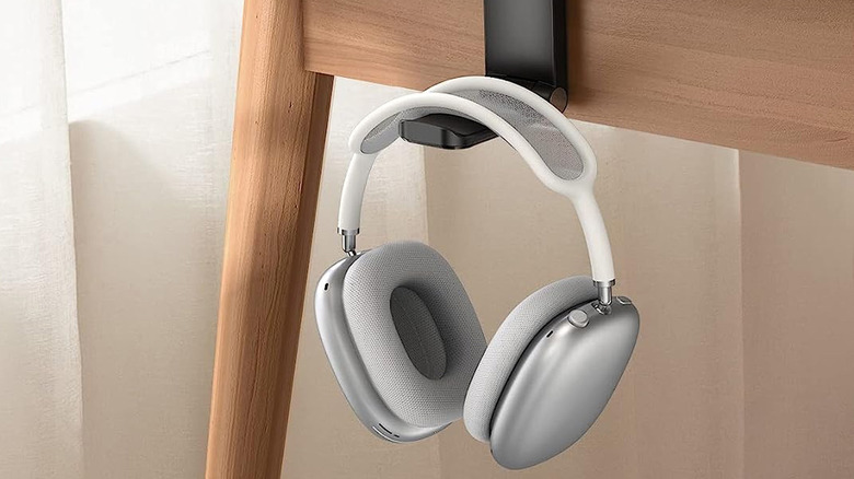 headphones hanging on holder off side of desk